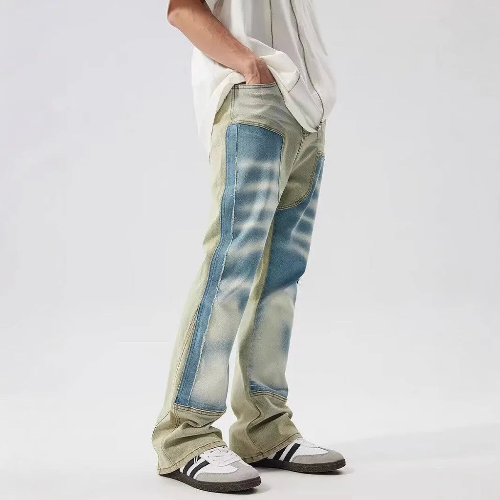 Retro yellow and blue patchwork jeans with splash-ink damaged design on denim fabric