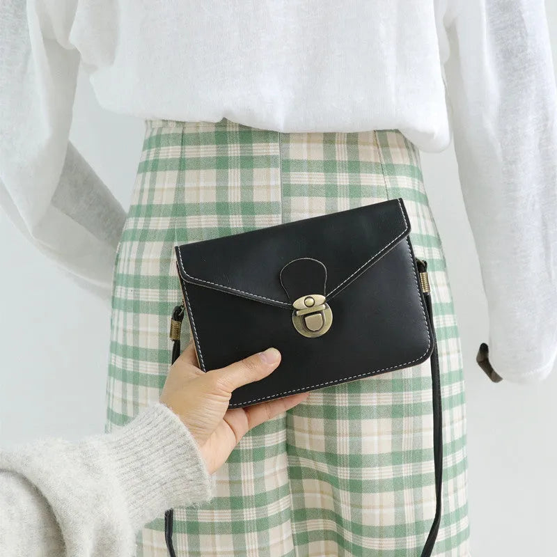 Retro soft surface crossbody messenger bag with flap closure in wine red colour showing internal phone pocket