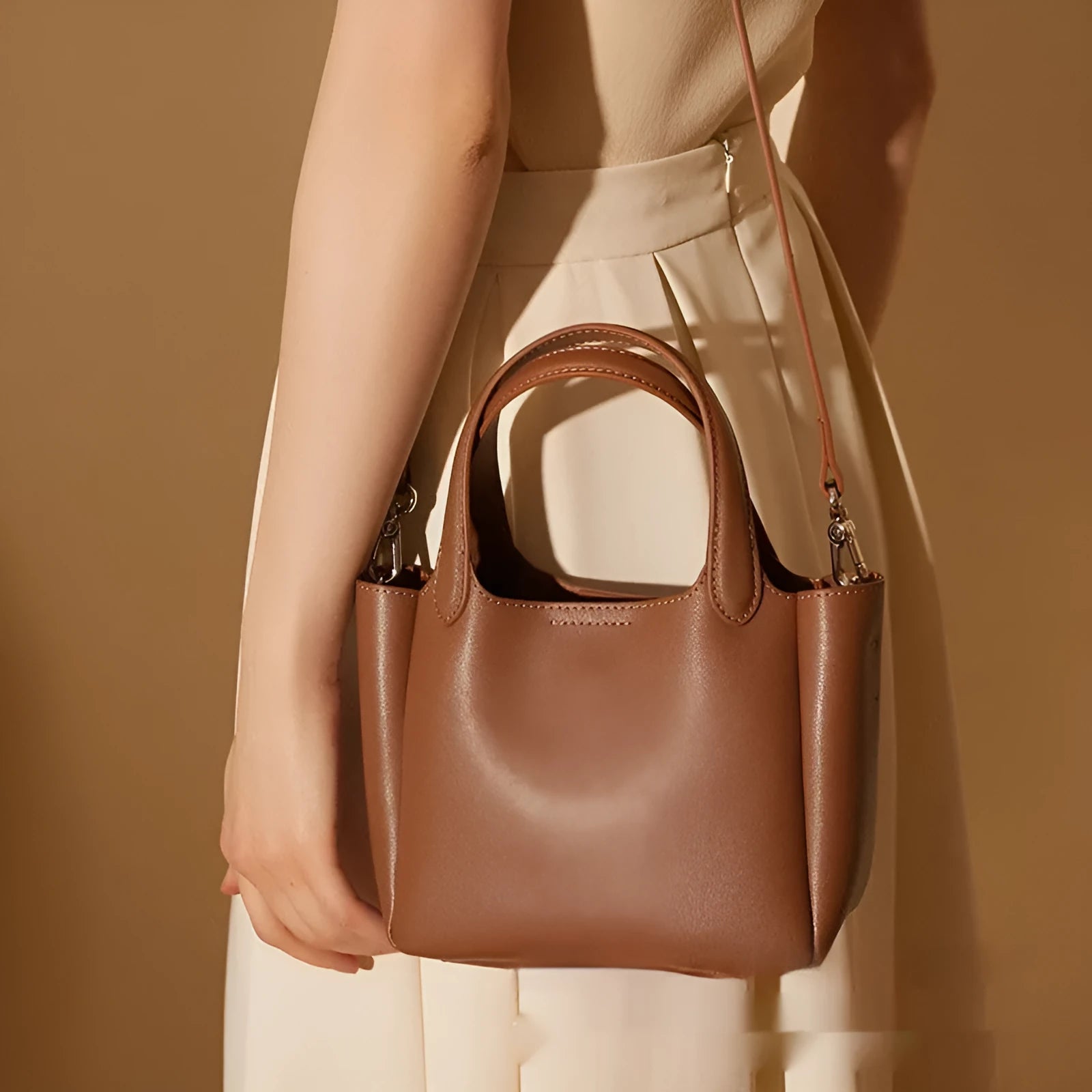 Brown cattlehide leather cross body bucket bag with square vertical design and slit pocket