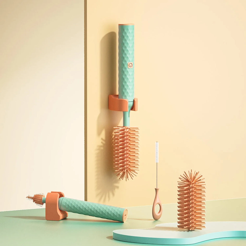 Pink and green electric rotating silicone bottle brush set for cleaning baby bottles and cups.