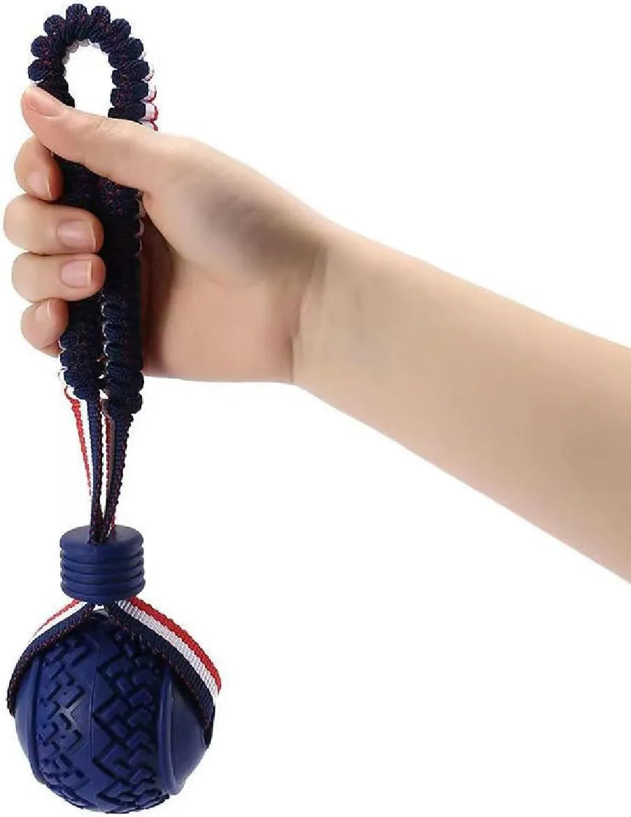 Red rubber dog ball with rope attachment showing textured surface and 29cm total length