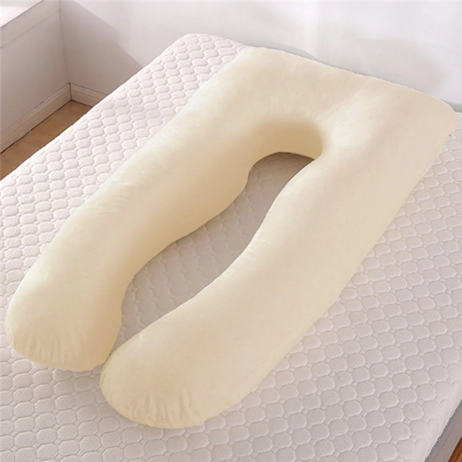U-shaped white maternity pillow with ice silk cover on a bed, showing its full-body support shape for pregnancy.