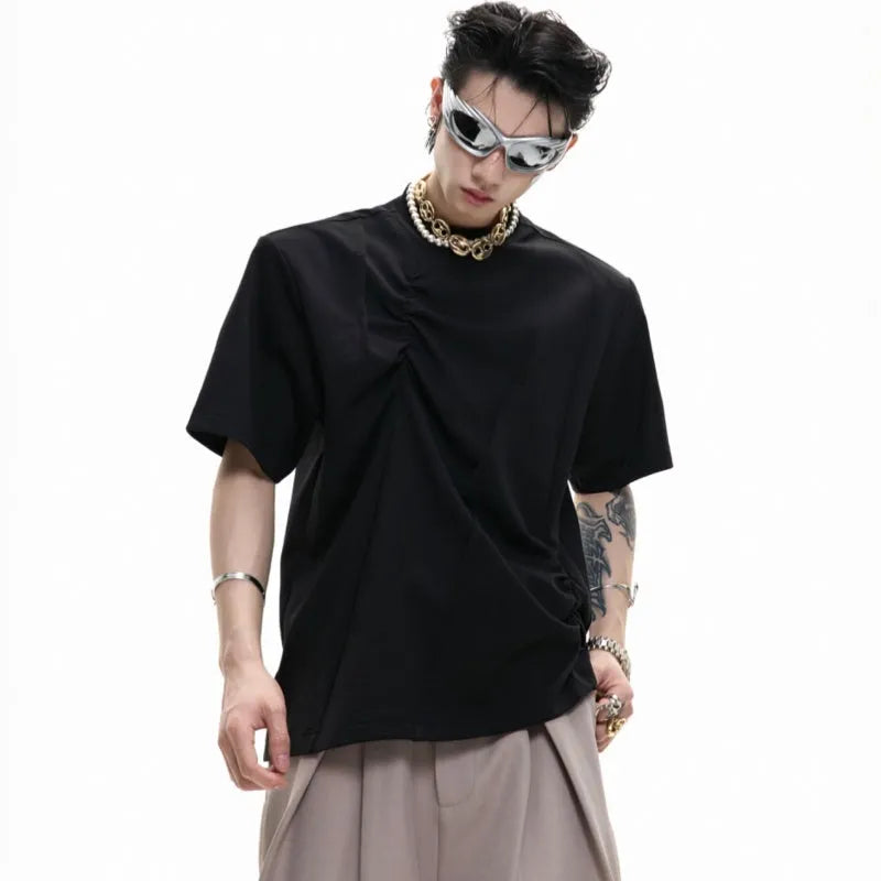 Man wearing a grey pleated cotton t-shirt with a round neck and loose fit.