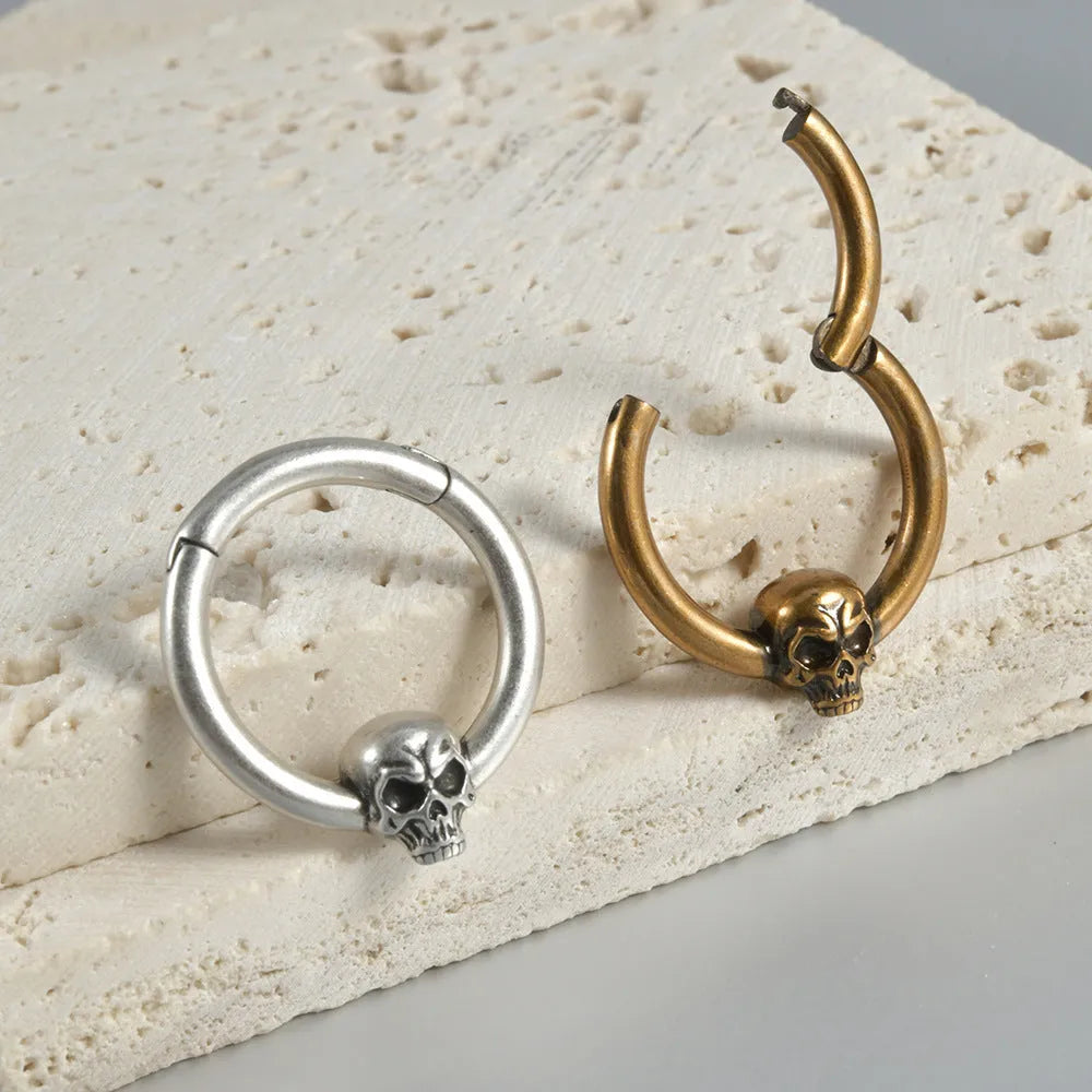 Close-up of copper punk earrings with a detailed ghost head design in antique silver finish.