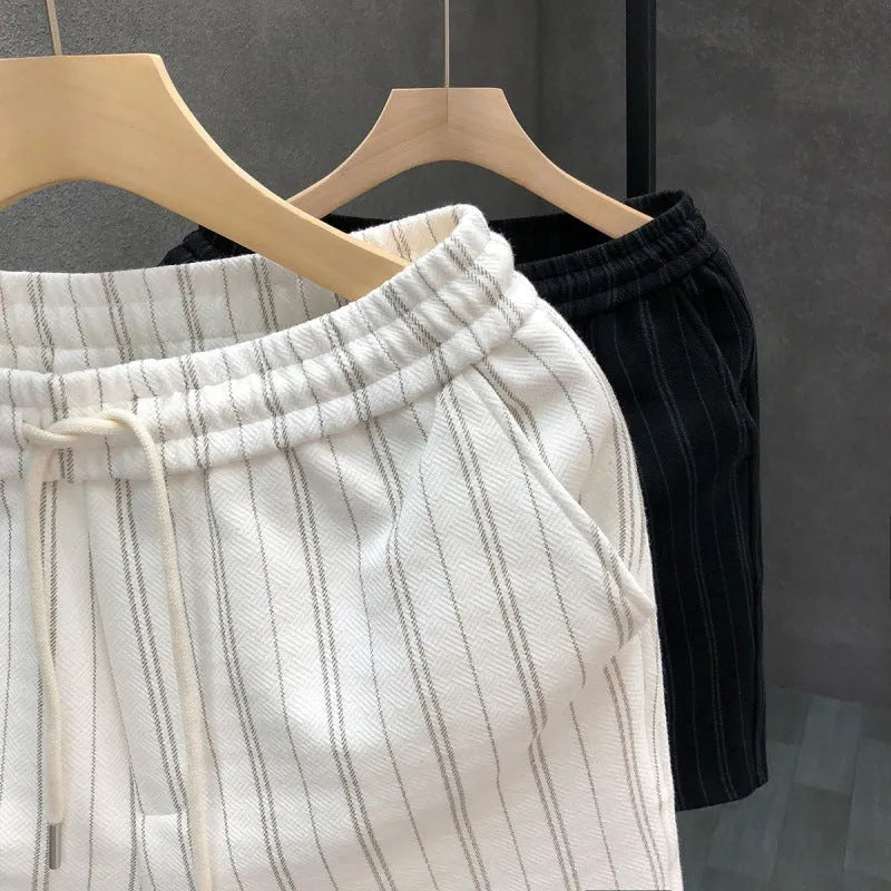 Men's black and white striped fleece-lined casual shorts on a neutral background.