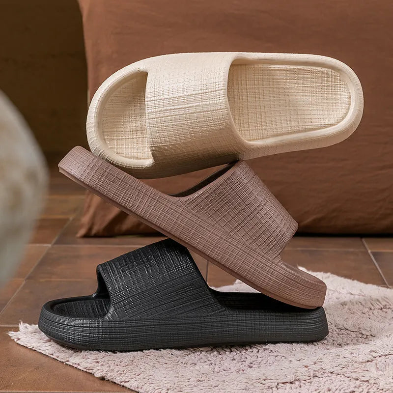 Women's soft EVA non-slip bath slipper in black, showing toe ring flip-flop design and textured sole.