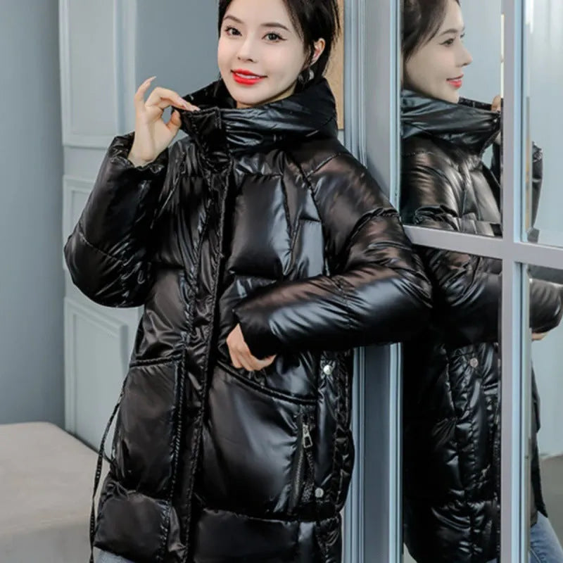 Green loose thick hooded women's winter jacket on a hanger, showing long sleeves and front zip.