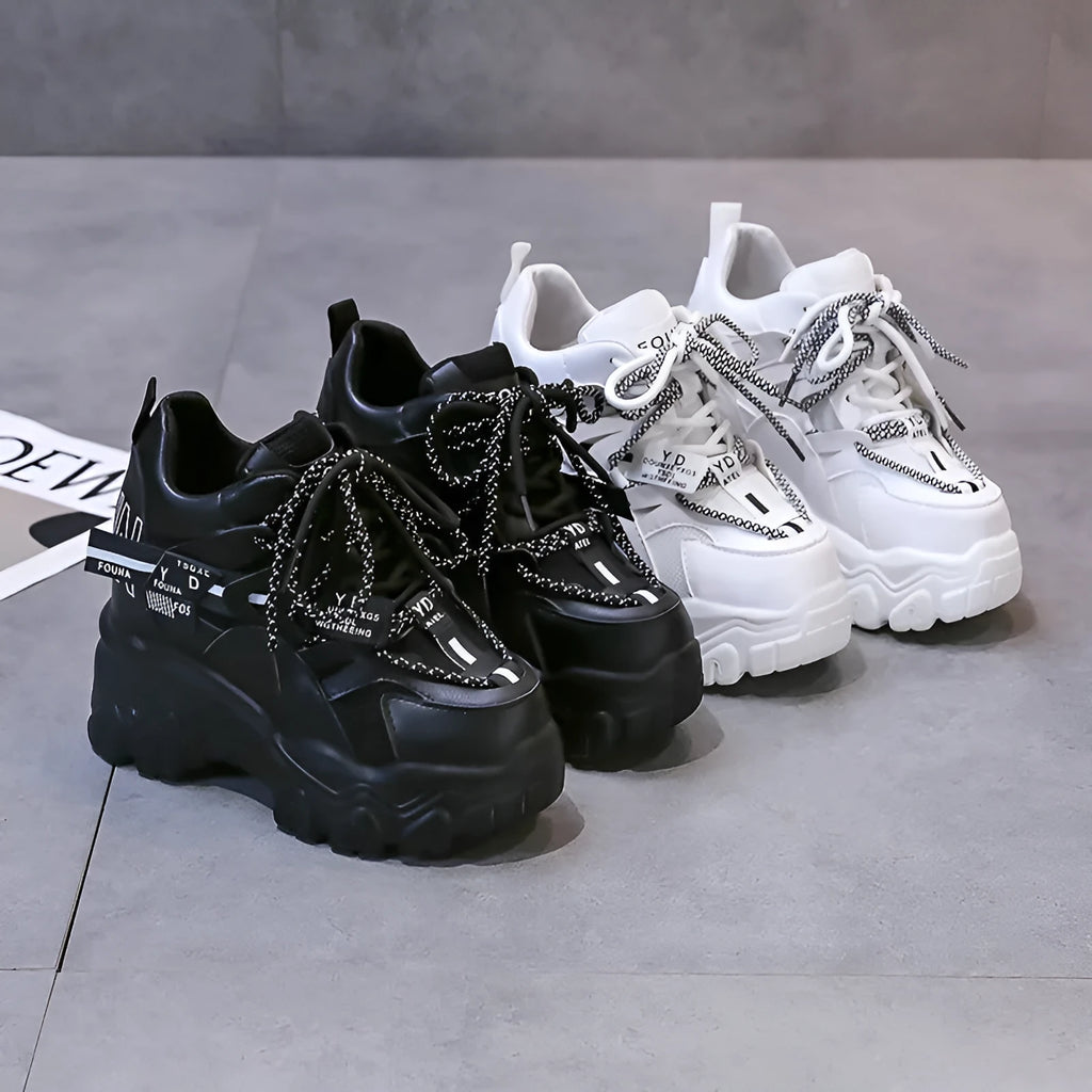 White women's low-top platform sports shoes with cross-strap and round toe on a rubber sole.