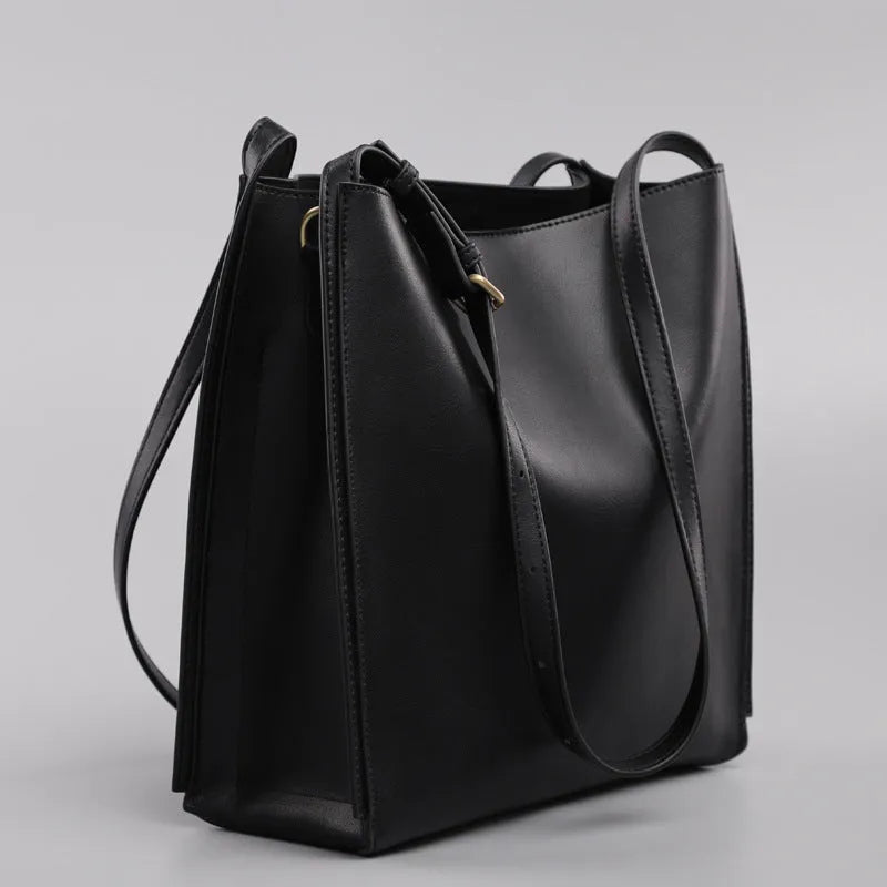 Brown genuine leather women's bucket bag with double shoulder straps and internal compartments.