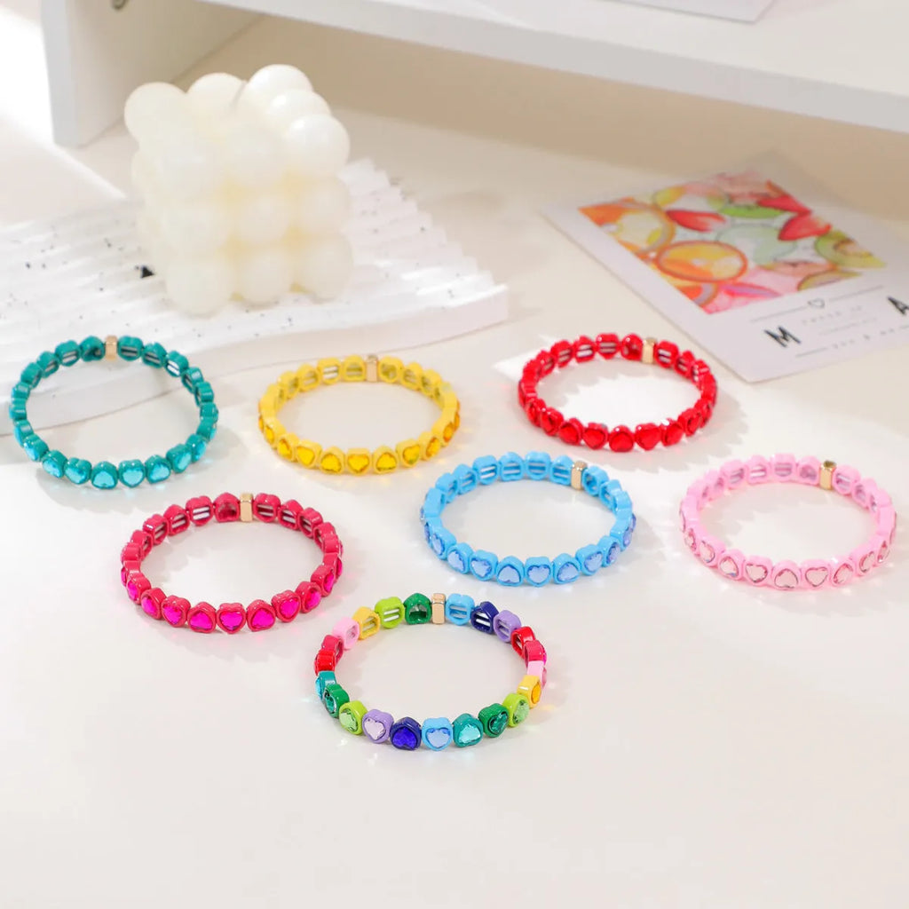 Rainbow coloured alloy heart charms on a stretchy elastic bracelet.
