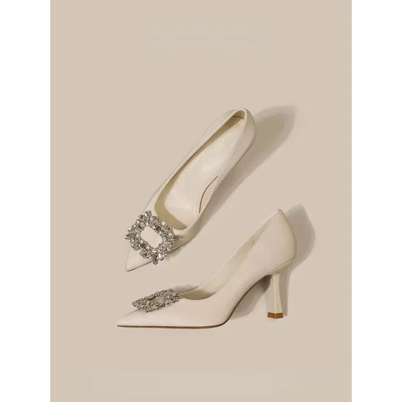 Women's pointed-toe stiletto heels in creamy white or black with a low-cut design and rubber sole.