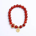 Natural red agate bead bracelet with woven design and blessing card on a neutral background.