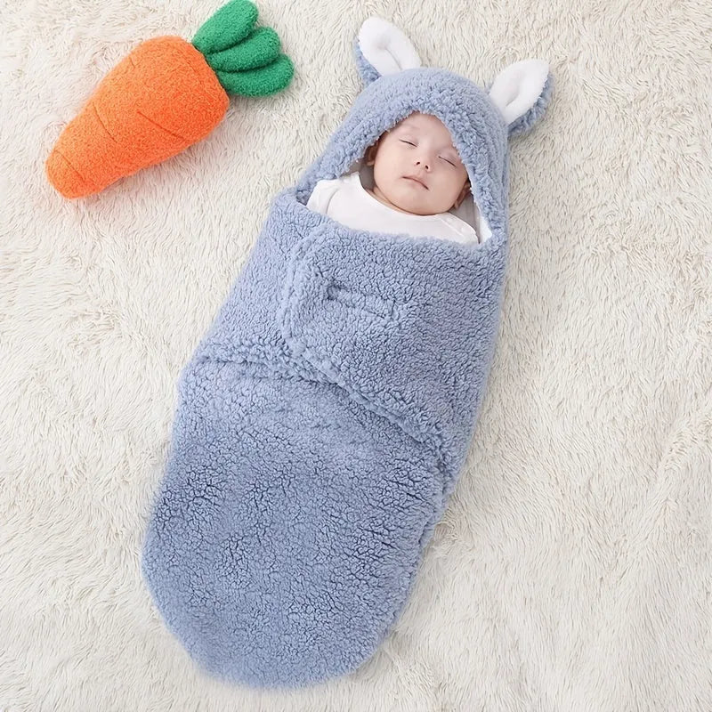 A baby wearing a soft grey fleece sleeping bag with hook-and-loop shoulder straps.