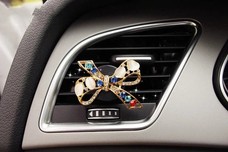 Alloy car fragrance clip with decorative charm attached to car air vent