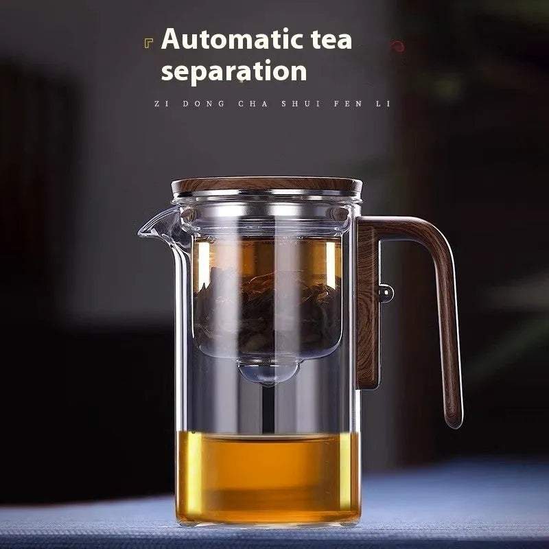 Glass teapot with wooden handle showing magnetic tea separation button and detachable inner infuser.