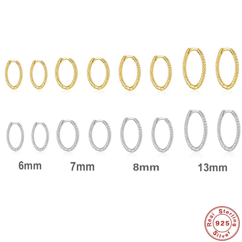 Close-up of twisted S925 sterling silver round ring earrings in gold colour on a plain background.