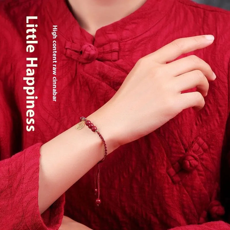 Cinnabar bracelet with braided rope in three colour options featuring round bead or flower blessing card charms
