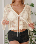 Women's apricot cropped cardigan blouse with flared bell sleeves, laid flat.