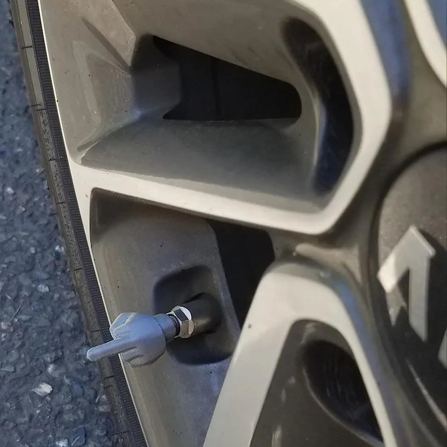 Set of four latex tyre valve caps, showing two skin colour and two black pieces, for car wheel protection.