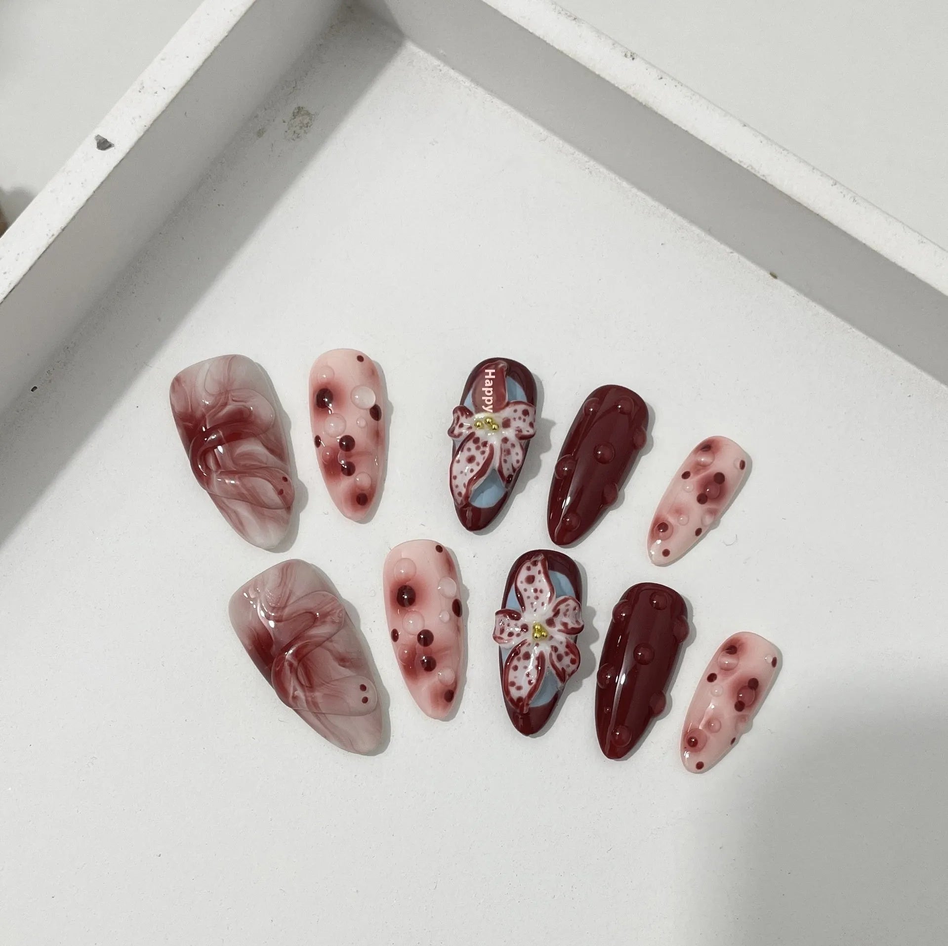 Hand-painted three-dimensional carved almond manicure nails with floral patterns in medium length