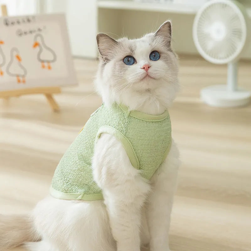Green knitted cat clothes with a hollowed-out bear patch cartoon design.