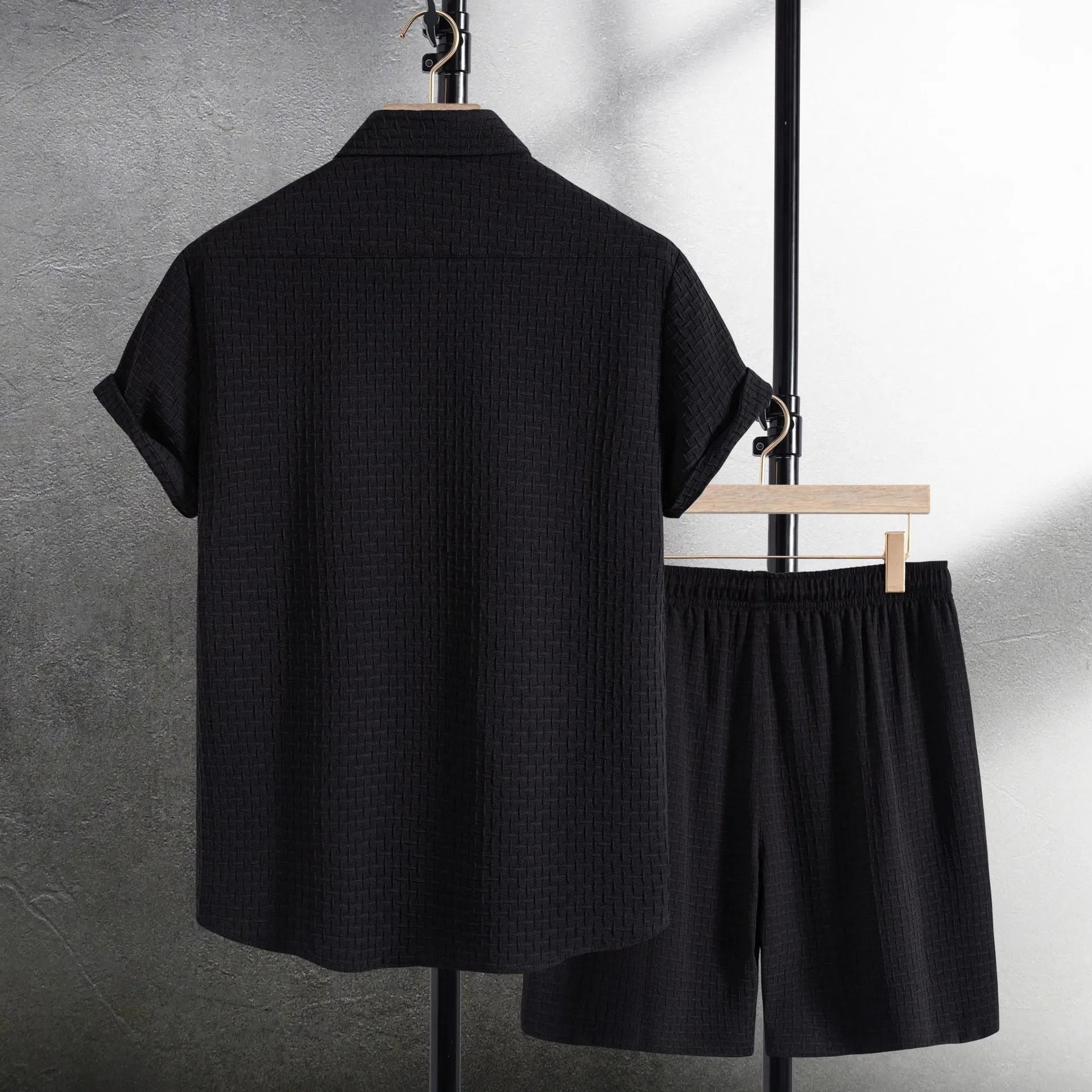 Men's black cotton blend short sleeve shirt and matching shorts laid flat as a summer set.
