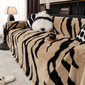 Zebra pattern flannel sofa cover draped over a sofa, showing non-slip underside and matching pillowcase.