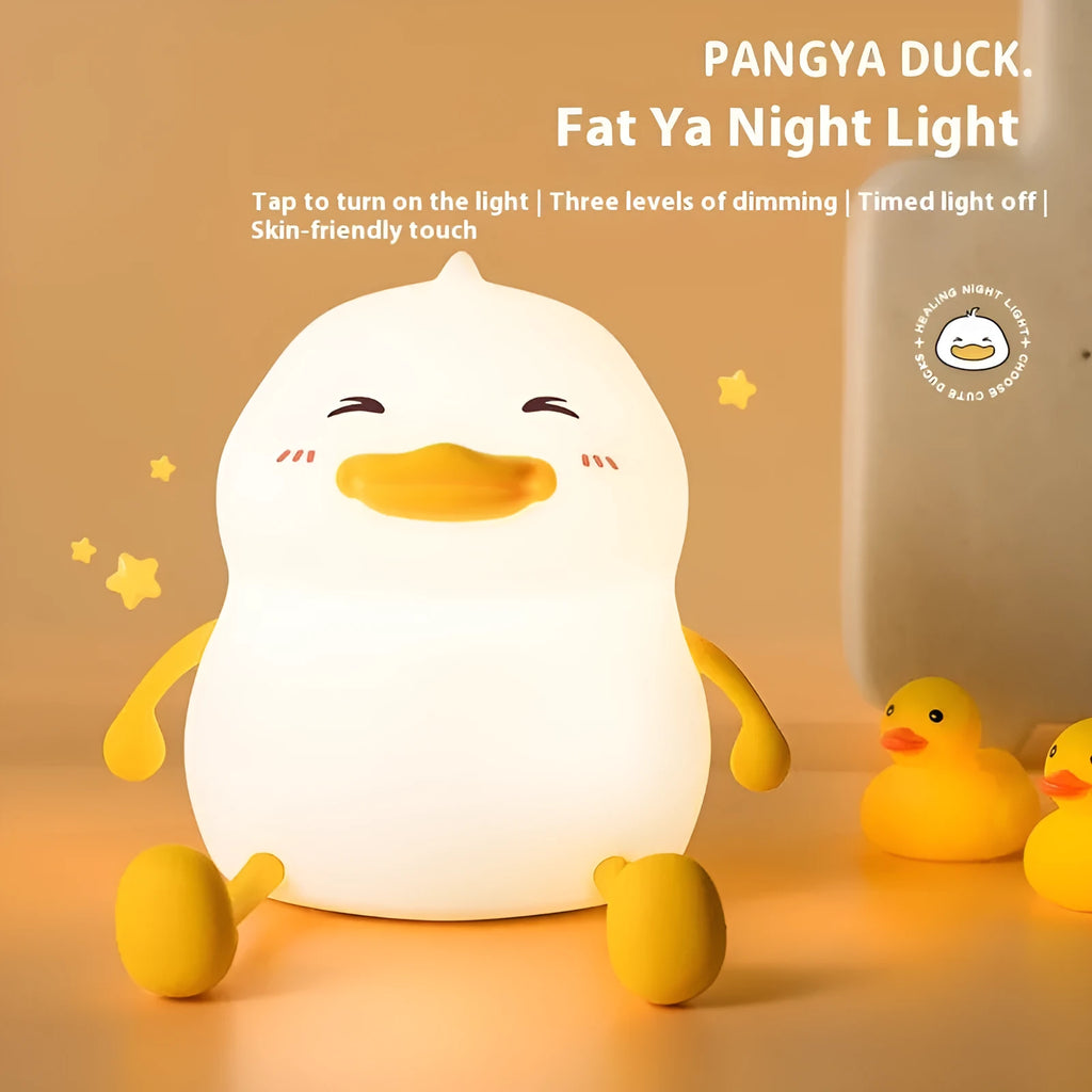Chubby silicone pat night light on a desk showing soft LED glow and USB charging cable.