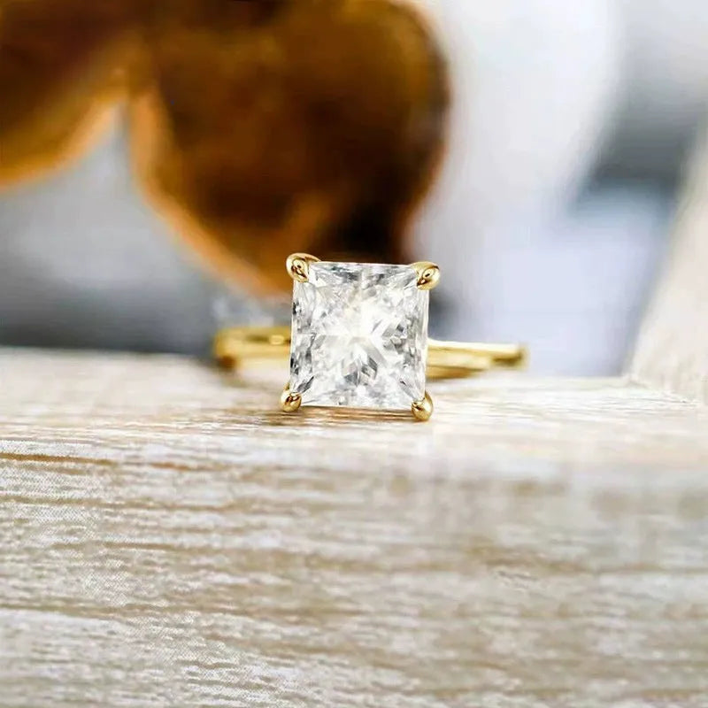 Women's geometric sterling silver ring in gold, rose gold, or silver on a grey background.