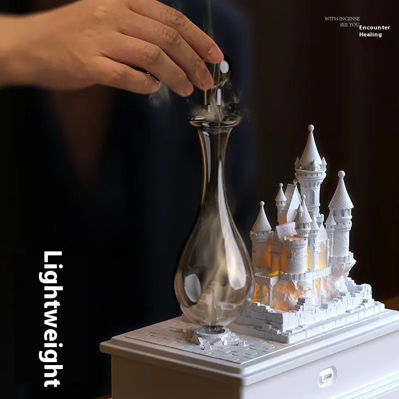 White medieval castle-shaped waterless aromatherapy machine with ambient light on a surface.