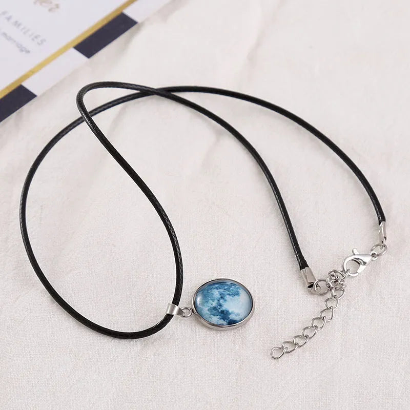 Luminous alloy moon and constellation pendant necklace with a coloured glass cabochon on a chain.