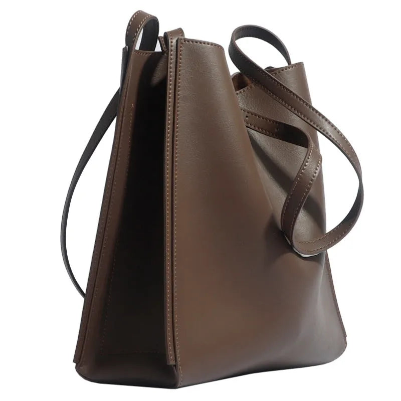 Brown genuine leather women's bucket bag with double shoulder straps and internal compartments.