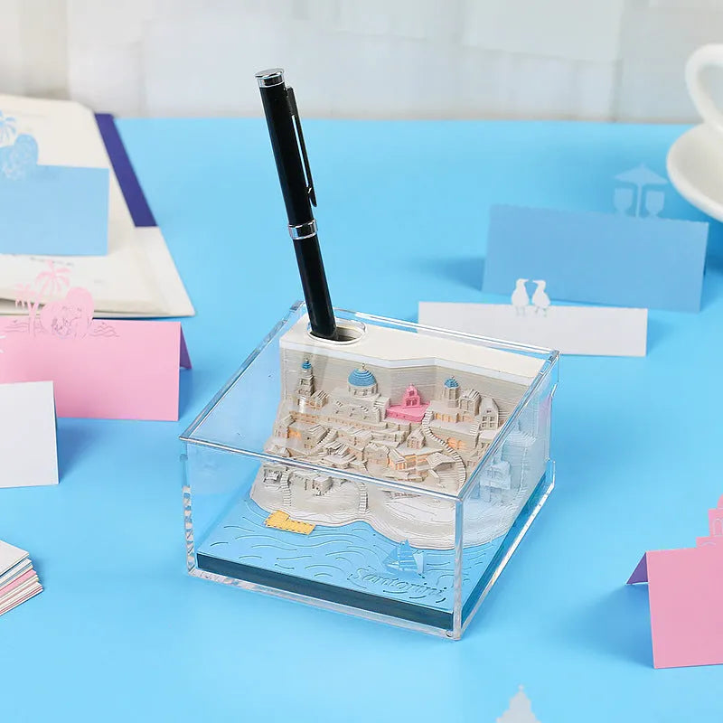 Assembled Santorini beach 3D paper model notepad with decorative lighting on a desk.