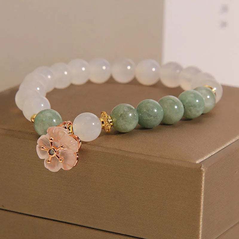 Emerald agate bracelet with white jade flower beads and pink accents on wrist