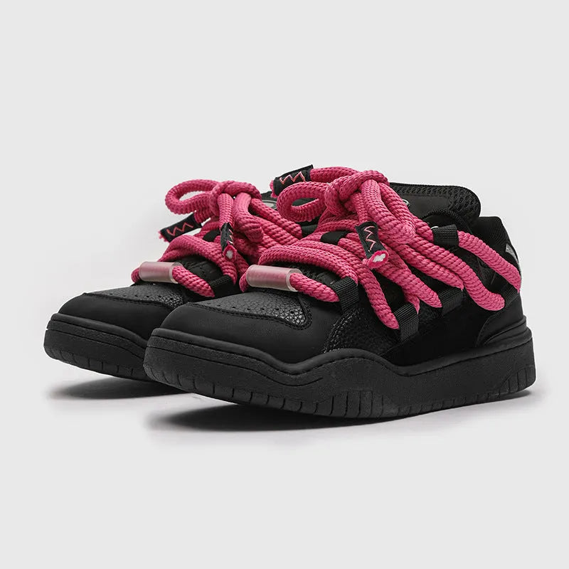 Pair of thick-soled casual lace-up trainers in a solid colour on a white background.