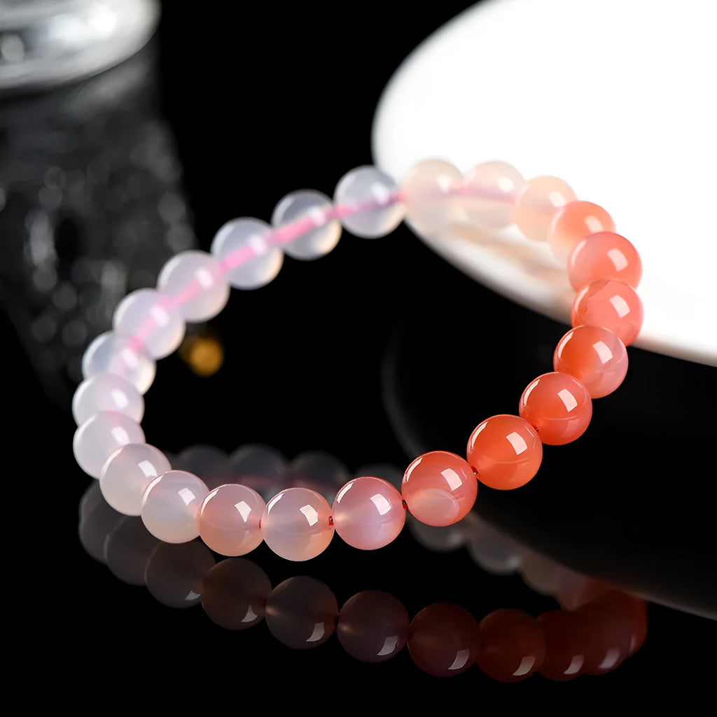 Natural gradient Yanyuan agate bracelet with geometric cut beads on a wrist.