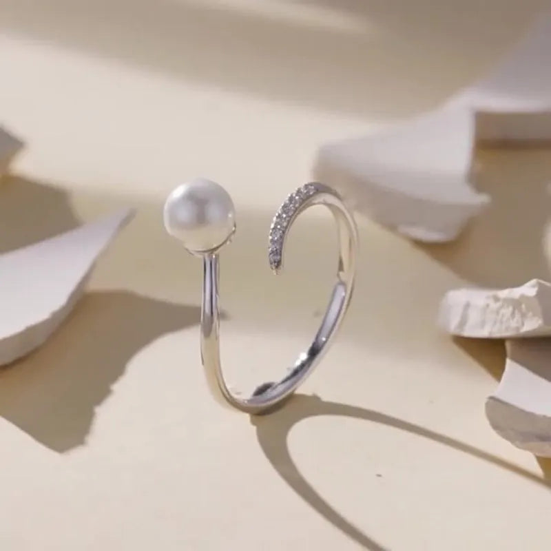 Adjustable S925 sterling silver ring with shell pearl centrepiece and open loop design