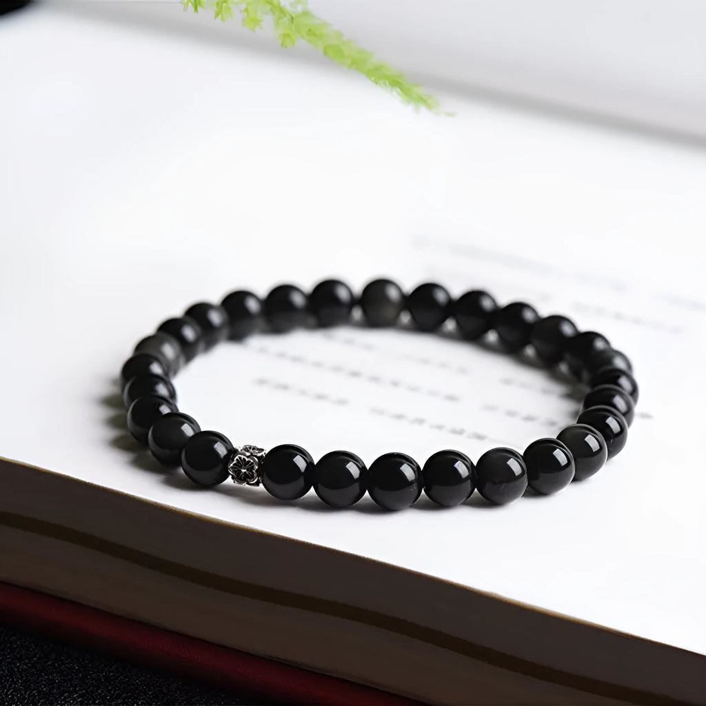 Natural obsidian bracelet with S925 sterling silver flower accessories on a wrist
