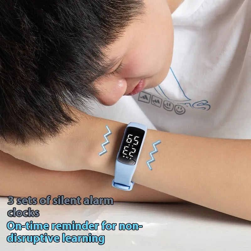 Vibration alarm clock watch with LED display and coloured silicone strap on a wrist.