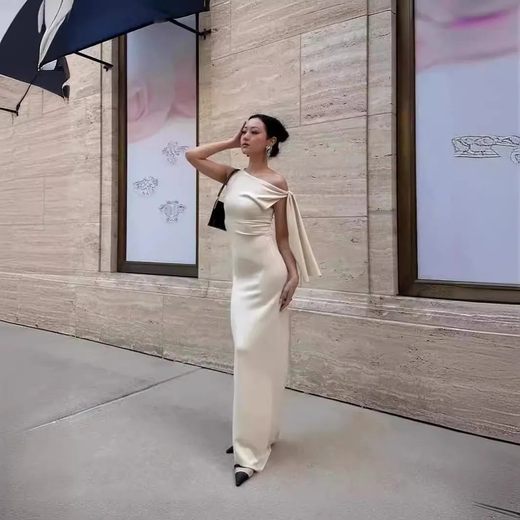 White sleeveless sloping shoulder long dress with high waist, hip skirt shape and fold detail in polyester