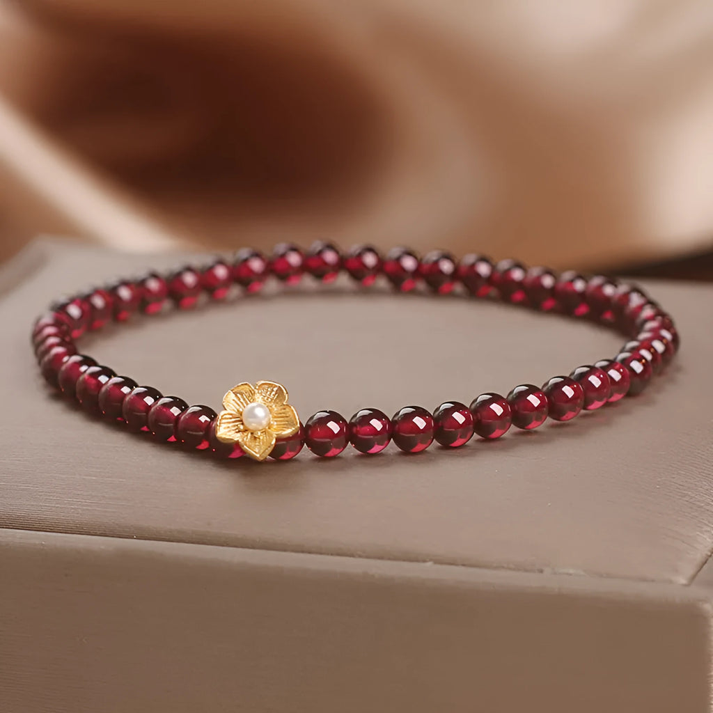 Red stone bead string bracelet with yellow flower accessories on wrist
