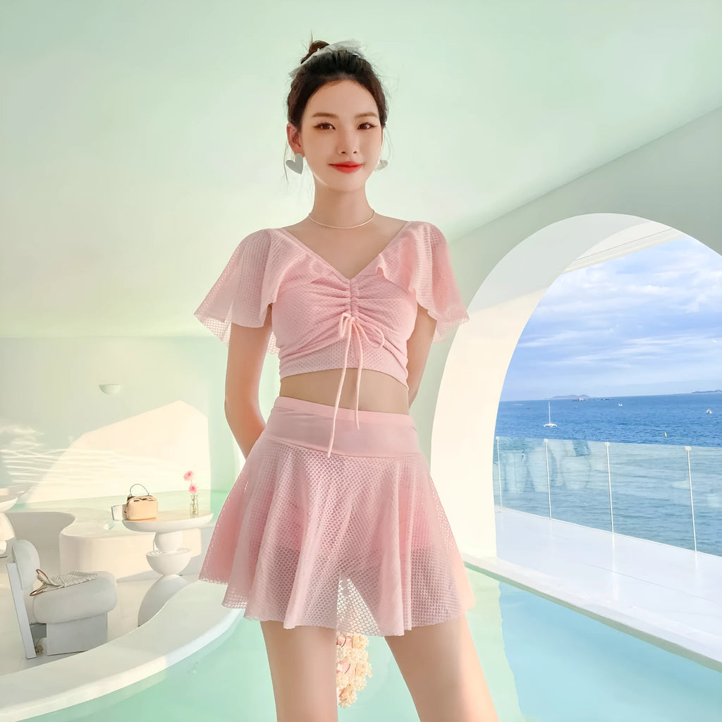 Women's solid colour two-piece swimsuit set with a skirt, shown in white, black, or pink.