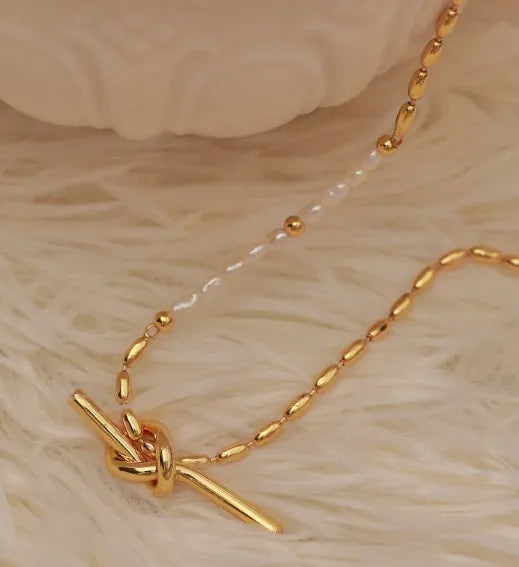 Gold electroplated natural real pearl necklace with copper geometric pendant and ring-line design on white background