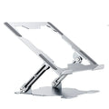 Grey aluminium laptop stand folded flat next to an open laptop, showing its adjustable angle and hollow design.