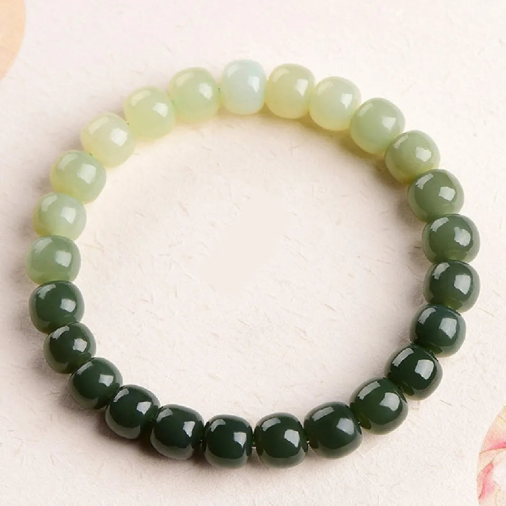 Natural Hetian jade water gradient bracelet with polished beads on a wrist.