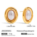 Close-up of a pair of round stainless steel stud earrings with a vintage-style pearl detail on a neutral background.