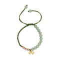 Close-up of a hand-woven red rope bracelet with floral design details on a wrist.