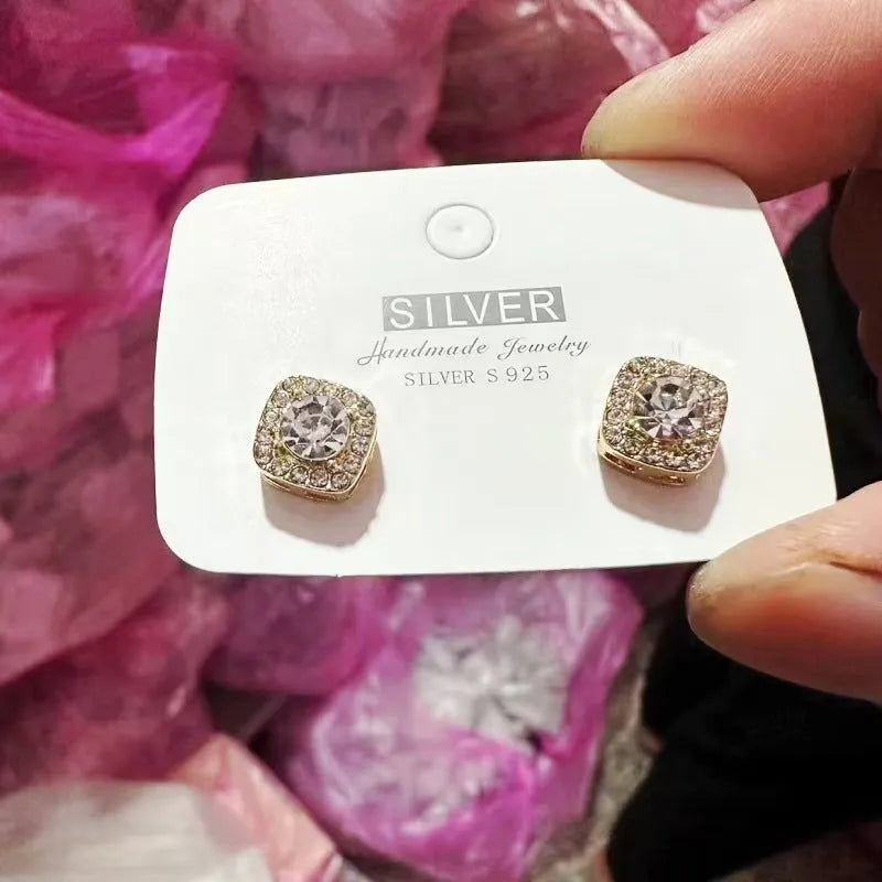 A pair of square-shaped geometric earrings with a diamond treatment detail, shown in a gold colour finish.