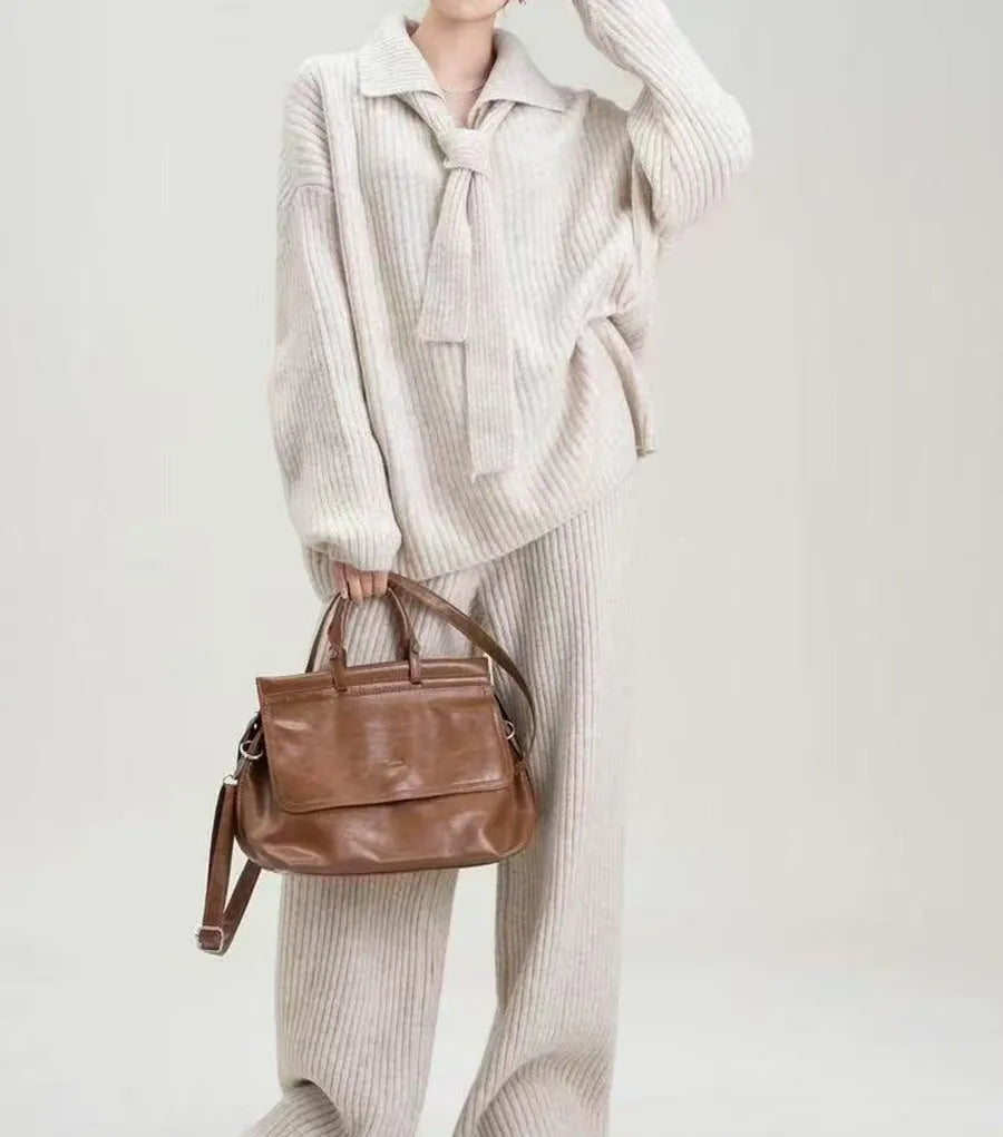 Women's dark grey acrylic knit sweater suit two-piece set with long sleeves and casual trousers.