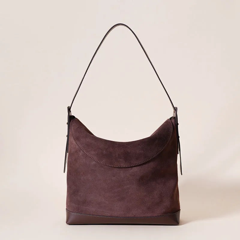 Light brown genuine leather women's retro shoulder bag with clamshell opening on a table.